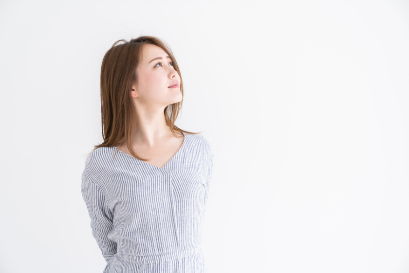 明るい空間で上を見上げる女性