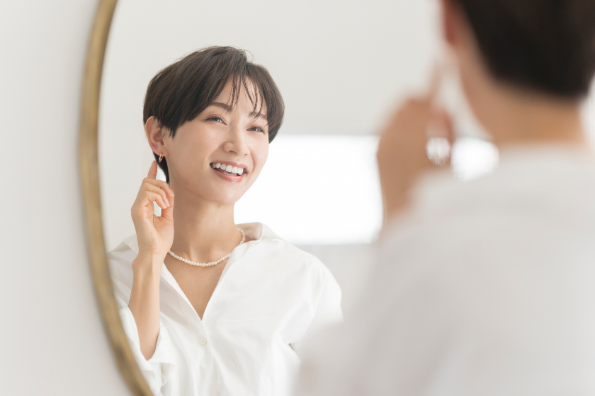 鏡を見ながら笑顔を見せる女性