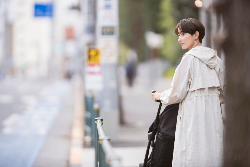 ベビーカーを押しながら街中で立ち止まる女性
