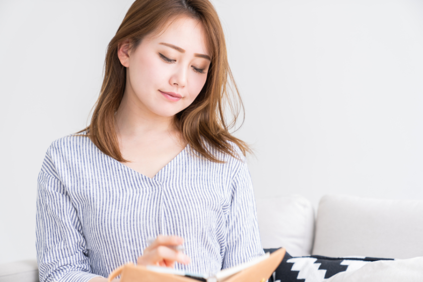 手帳を開いて考えを整理する女性