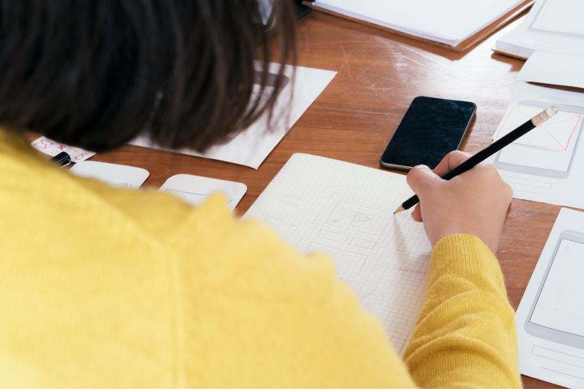 ノートに書き出しながら競合媒体の役割を整理する様子