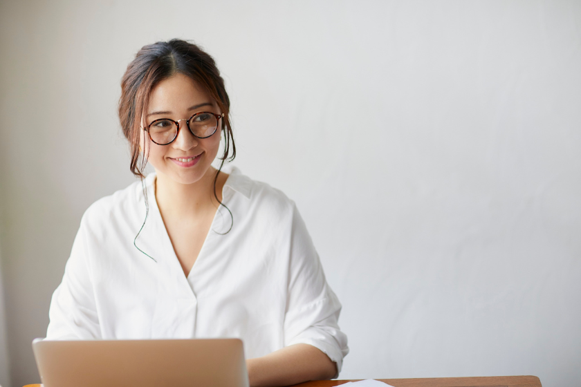 ノートパソコンの前で微笑む女性。小さな事業ができるサステナビリティを考える記事のアイキャッチ画像