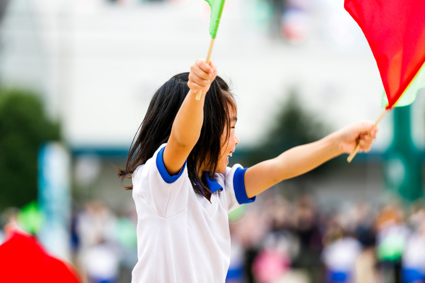 運動会で旗を振る子ども